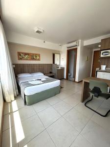 - une chambre avec un lit, un bureau et une chaise dans l'établissement SM622 Flat região central Próx Embaixada Americana, à Brasilia