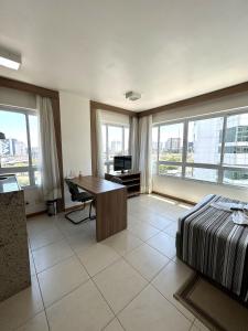 um quarto com uma cama, uma secretária e janelas em SM622 Flat região central Próx Embaixada Americana em Brasília