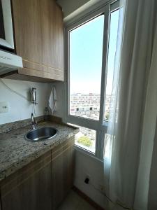 a kitchen with a sink and a large window at SM622 Flat região central Próx Embaixada Americana in Brasilia +10 photos