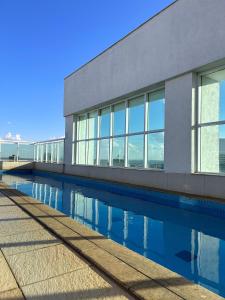 a building with a swimming pool in front of it at SM622 Flat região central Próx Embaixada Americana in Brasilia