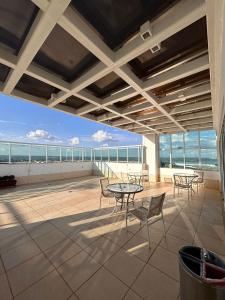 d'une terrasse sur le toit avec des tables et des chaises. dans l'établissement SM622 Flat região central Próx Embaixada Americana, à Brasilia