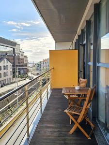 a balcony with a wooden table and chair on a building at Anadia Atrium in Funchal