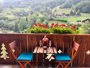 Apparthotel Mountain River Resort في فال دي ليز: طاولة مع زجاجة من النبيذ وكرسيين