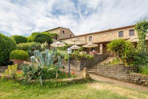 a house with a stone wall and some plants at Le Valli Tuscany in Pomarance