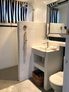 y baño con lavabo, aseo y espejo. en Avalon Beach Cottage- The Islander en Avalon