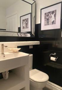bagno con servizi igienici, lavandino e specchio di Avalon Beach Cottage- The Islander a Avalon