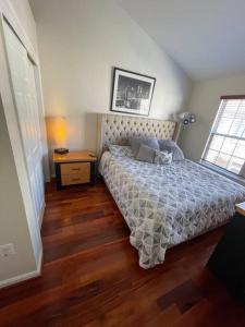 a bedroom with a bed and a wooden floor at Beautiful & Luxurious 2 bed 2 & half bth & 2 car attached garage TownHouse in Falls Church in Falls Church