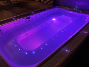 una bañera púrpura con luz morada. en Villa Siirtola, en Koro