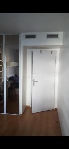 a white door in a room with a bedroom at Room cosycosy in Clichy