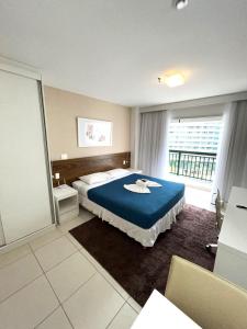 a bedroom with a bed and a large window at V717 Maravilhoso flat em Brasília in Brasilia
