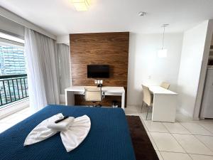 a bedroom with a bed and a desk and a television at V717 Maravilhoso flat em Brasília in Brasilia