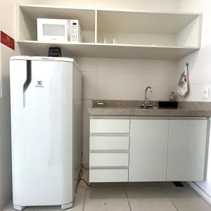 a small kitchen with a refrigerator and a microwave at V717 Maravilhoso flat em Brasília in Brasilia