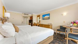 a hotel room with two beds and a desk at La Mer Beachfront Resort in Cape May