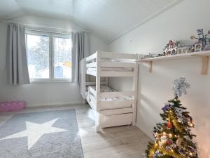 a room with a christmas tree and a bunk bed at Villa Arctic Aurora in Rovaniemi