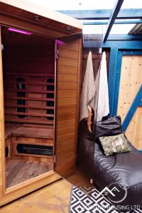a sauna with a black leather couch in a house at Lilly Cottage Romantic Log Burner and Sauna Retreat in Chester