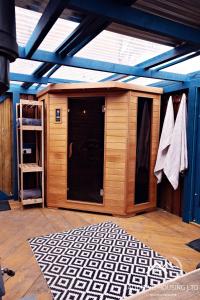 a large wooden shed with a door and a rug at Lilly Cottage Romantic Log Burner and Sauna Retreat in Chester