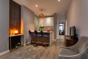 a living room with a bar with blue chairs at THE PAD at Sloane Square in London