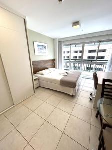 um quarto com uma cama e uma grande janela em F1104 Flat de ótima localização e fácil acesso em Brasília