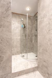 a shower with a glass door in a bathroom at THE PAD at Sloane Square in London