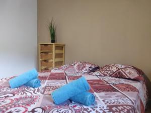Una cama con dos toallas azules encima. en La Terrasse en Le Carbet