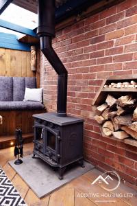 a stove in a room with a brick wall at Lilly Cottage Romantic Log Burner and Sauna Retreat in Chester