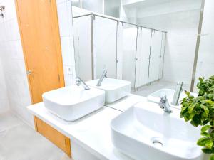 CAPSULE INN VALENCIA Hostel في فالنسيا: حمام مغسلتين ومرآة