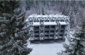 un gran edificio con nieve encima en Apartman Virgin Forest - FREE Garage Bjelašnica en Bjelašnica
