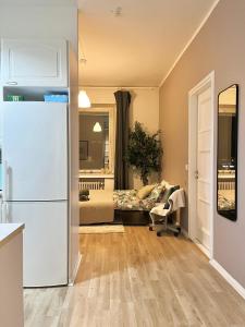 a kitchen with a white refrigerator and a bedroom at Chic Urban Oasis at Helsinki Activity Center in Helsinki