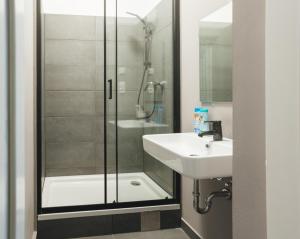 y baño con ducha y lavamanos. en Malfatti Room Oasis with coworking space, en Viena