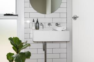 bagno con lavandino bianco e specchio di The Pelican Shed a Robe