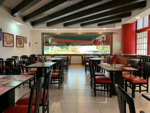 a dining room with tables and chairs in a restaurant at Hotel Santa Irene Guadalajara in Guadalajara