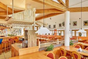 um restaurante com mesas e cadeiras de madeira e uma grande sala em Trip Inn Aktivhotel & Restaurant Sonnenhof bei Passau em Sonnen