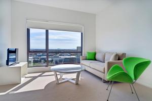 a living room with a couch and a table and a window at MCentral Apartments Manukau in Auckland