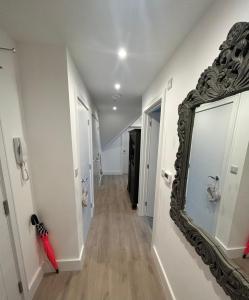 a hallway with a mirror on the wall at The Penthouse Double Bedroom for Rent Use of kitchen in Epsom +1 photo