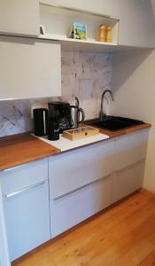 uma cozinha com armários brancos e um lavatório em Tæt på Langesø em Morud