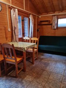 a dining room with a table and chairs and a couch at Domki Energetyk in Pogorzelica