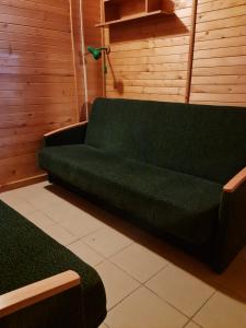 un sofá verde está sentado en una habitación en Domki Energetyk en Pogorzelica