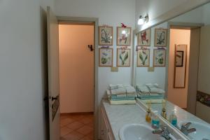 La salle de bains est pourvue d'un lavabo et d'un miroir. dans l'établissement Appartamento Margaritone, à Arezzo