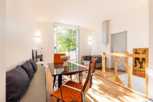 a living room with a table and a couch at Appartement 50m2 parfait état avec piscine privée in Bordeaux