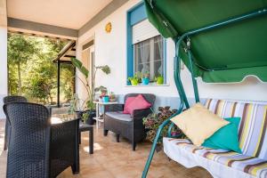 - une terrasse couverte avec des chaises et un parasol vert dans l'établissement Valateddi, à Cammarata