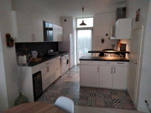 a kitchen with white cabinets and a tile floor at Le cocon zen in Voiron