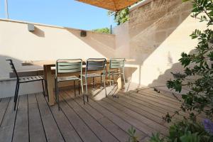 a wooden table and chairs on a patio at Uzès médiévale l'écrin d'Amalia in Uzès +19 photos