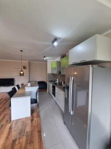 a kitchen with a stainless steel refrigerator and a table at Hawaii- 2 bdr, Arena, Sava centar, FREE PARKING in Novi Beograd