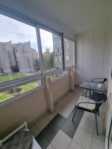 a room with a chair and a table and windows at Hawaii 08, 2 bedrooms, with garage in Novi Beograd