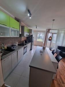 una cucina con banconi bianchi e armadi verdi di Hawaii 08, 2 bedrooms, with garage a Novi Beograd
