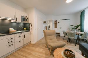 Il dispose d'une cuisine et d'un salon avec une table et une salle à manger. dans l'établissement Modernes 2-Zimmer Themen-Apartment "Stadtwäldchen" im Zentrum, à Bayreuth