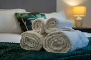 a pile of towels sitting on top of a bed at Stylish LUXE 4Beds Abbey Rd St Johns Wood in London
