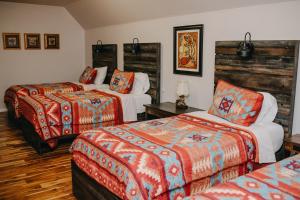 una habitación de hotel con dos camas con naranja y azul en The Lodge at Lakeshore, en Belle River