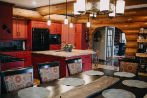 cocina con armarios rojos, mesa y sillas en The Lodge at Lakeshore, en Belle River