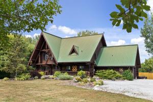 Casa de madera grande con techo verde en The Lodge at Lakeshore, en Belle River